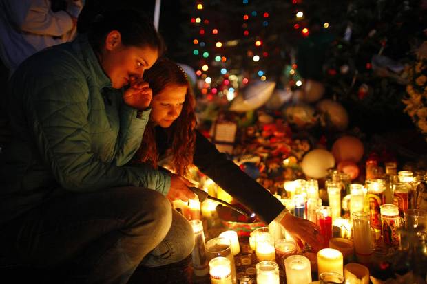 Dec. 18, 2012: Girls light candles at a memorial in Newtown, Conn., set up to honour the victims of the shooting at Sandy Hook Elementary School.