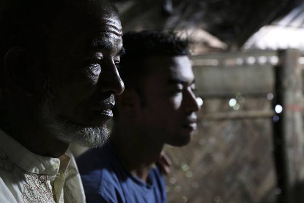 Abul Taher sits with his son Muhammad Selim, who left Bangladesh earlier this year as part of a tide of people seeking better prospects in Malaysia. When Mr. Selim was at sea, traffickers extorted money from his family and killed other passengers on his boat. He eventually landed in Indonesia but was returned to Bangladesh.