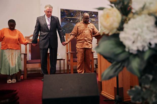 Virginia Gov. Terry McAuliffe holds hands and prays with Dr. Alvin Edwards, pastor of Mt. Zion First African Baptist Church, Aug. 13, 2017 in Charlottesville.
