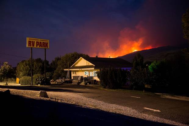 A wildfire burns on a mountain behind an RV park office in Cache Creek, B.C. in the early morning hours of Saturday, July 8, 2017.