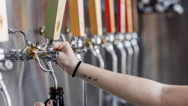 Beer is poured into a growler at Strange Fellows Brewing Co in Vancouver.