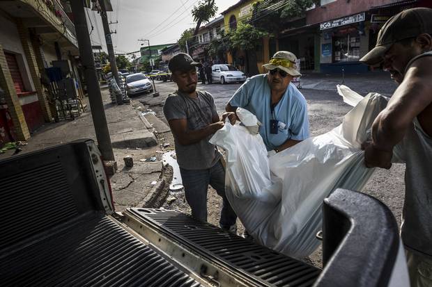 A team from the medical examiner's office take a body to the morgue in San Salvador, El Salvador, May 29, 2015.