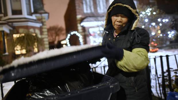A 63-year-old Chinese grandmother, looking for bottled, closes the lid on a recycling bin, set out for collection the following morning.