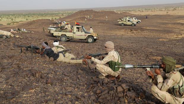 Tuareg fighters stand with weapons near Kidal, northern Mali, on Sept. 28.