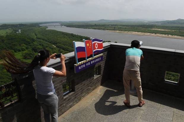 Visitors look out toward Russia, left, and North Korea, right, at the viewing tower in Hunchun.