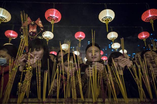 People pray and burn joss sticks at Wong Tai Sin temple to welcome in the Lunar New Year in Hong Kong early on February 8, 2016.