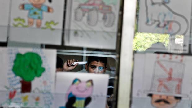 A teenager returning home after a failed escape attempt waits as his parents are interviewed at the Care Center for Migrants in the city of Santa Tecla, El Salvador.