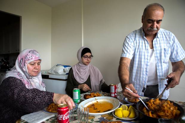 Mr. Sharbaji serves up a traditional eal from Aleppo with Sedra and his wife, Mouna, left.