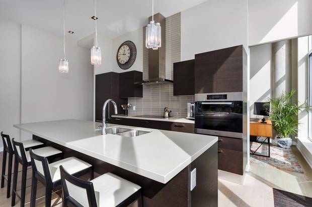 The kitchen features a built-in oven and induction cooktop.