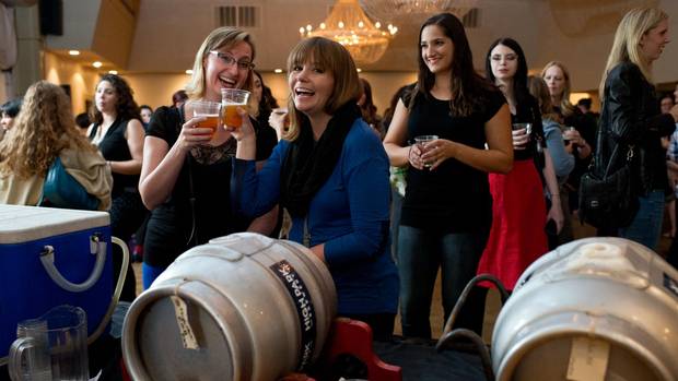 Laura MacDonald, left, and Yvonne Gettins try one of the local brews available at an event put on by the Society of Beer Drinking Ladies in Toronto, Sept. 30.