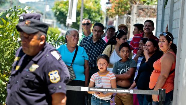 Relatives wait as a bus arrives with a group of children being sent back from Mexico at the Care Center for Migrants in Santa Tecla, El Salvador.