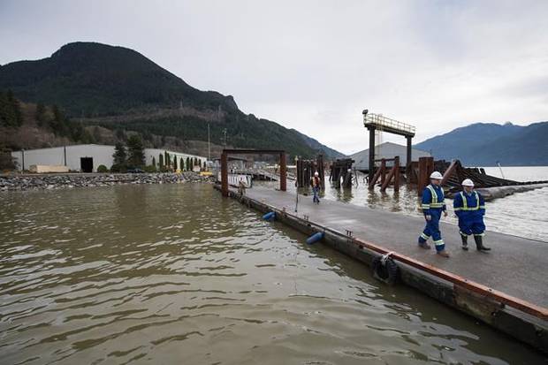 Workers walk on a dock at the Woodfibre LNG project site.