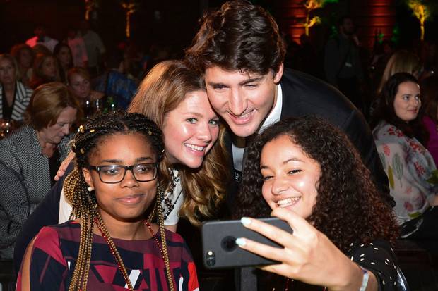 Mr. Trudeau and Ms. Grégoire Trudeau pose for a selfie with young students at the Fortune summit at Washington's Smithsonian American Art Museum.