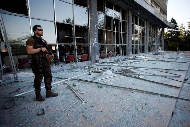 Men look at damage caused by fighting during a coup attempt at Turkish police special forces base near Ankara, Turkey, July 19, 2016.