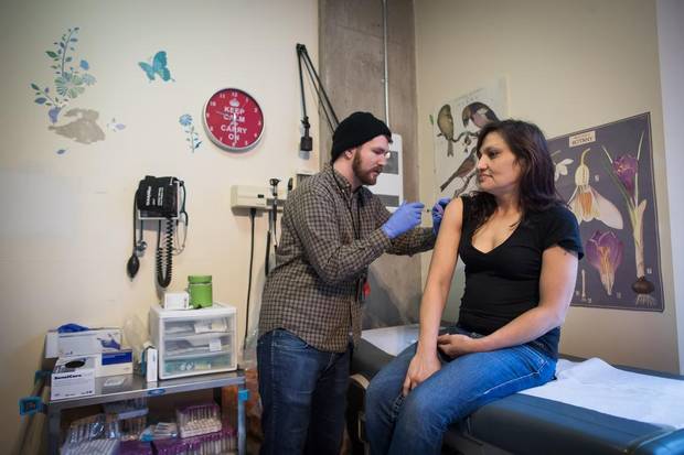 Registered Nurse Tim Parizeau, left, administers a dose of hydromorphone to Melody Cooper.