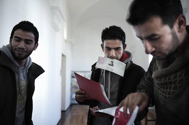 Osama Omran, Zain Al Abedin Omran and Basel Omran after receiving their first official German identity cards at the district administration office in Munich.