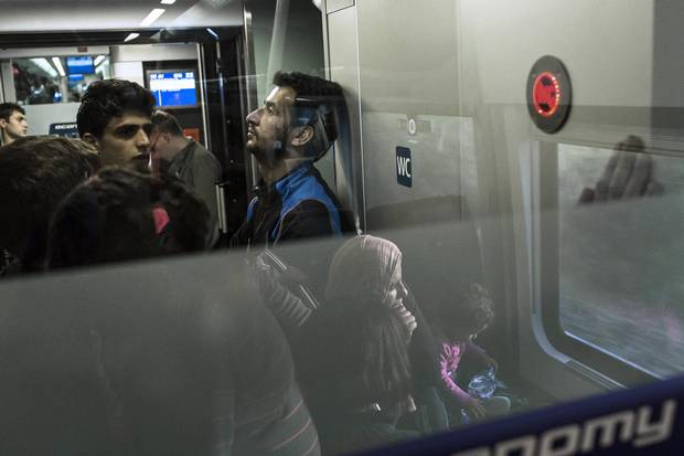 Says Basel Omran, centre, seen here on a train bound for Munich: ‘I would hold all the happiness in the world in my hands if my family were here.’