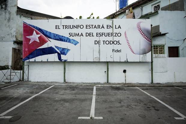 The stadium where the Industriales team plays features a quote attributed to Fidel Castro: “Victory will be in the sum of efforts of all,” in Havana, Dec. 20, 2014. Whether in organized games on diamonds with frayed backdrops or in pickup games in the street, baseball is still very much a part of Cuba’s people.