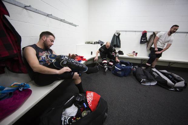 Members of the Calgary Pioneers hockey team get dressed before their game in Calgary on Dec. 3, 2016.