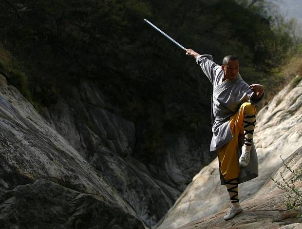 A warrior monk of the Shaolin Temple displays his Kung Fu skills at the Songshan Mountain.