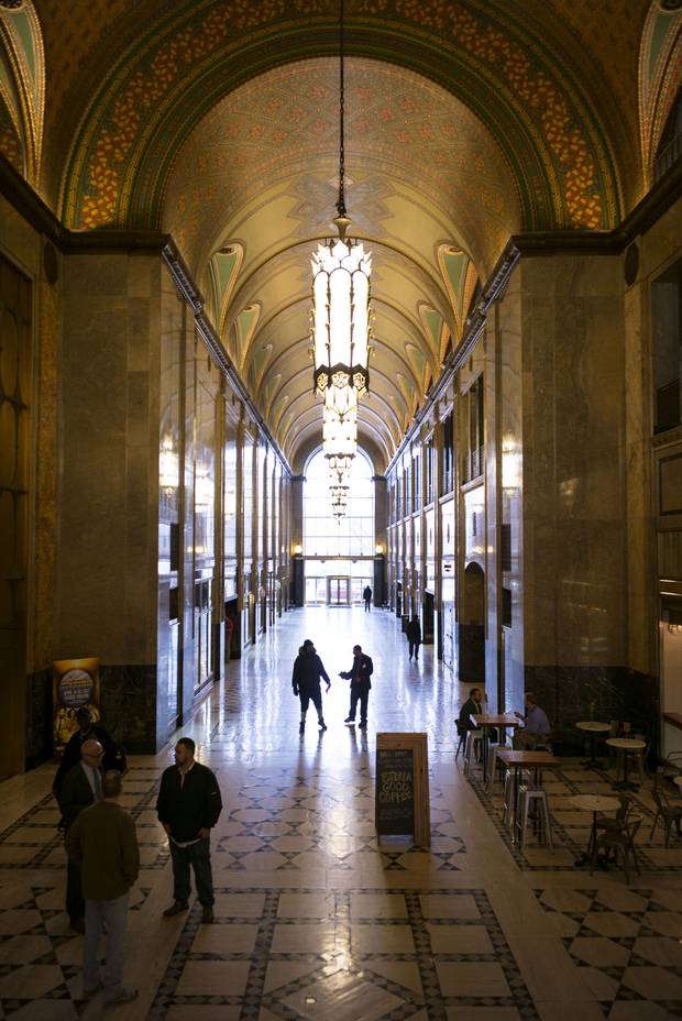 People walk through the main arcade of the Fisher Building.