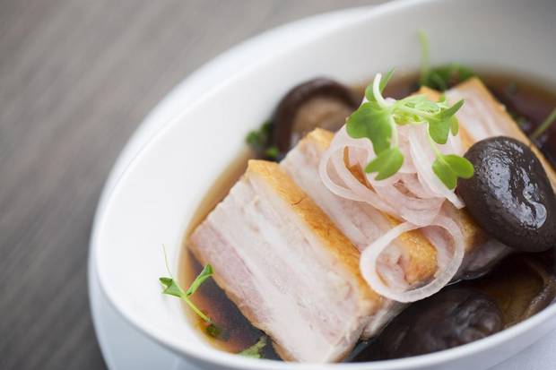 Pork belly with warm dashi broth, shiitake, pea greens, and pickled shallots at The Salted Vine in Squamish, B.C.