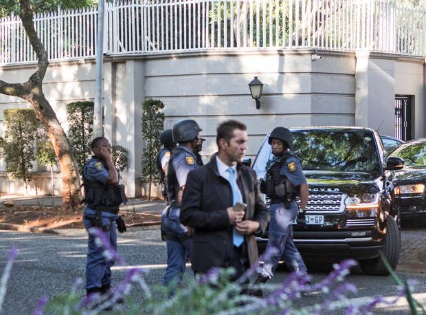South African police officers stand guard at the Gupta family compound in Johannesburg on February 14.