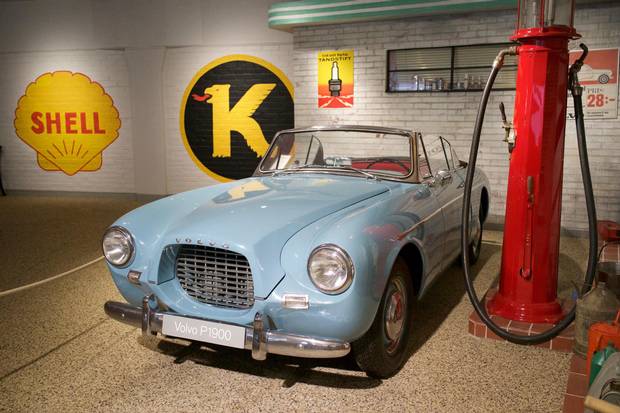 A Volvo P1900 displayed at a retro gas station exhibit at the Volvo Museum.