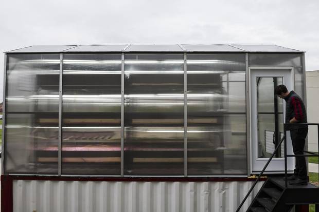 The ground floor is filled with a large fish tank, along with a system of pumps and filters that provide nutrient-rich water to the greenhouse set atop the shipping container.