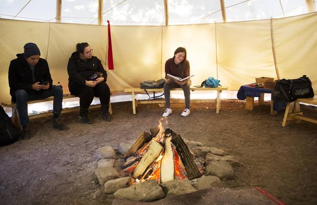 First Nations Trent University students sit in a campus tepee in Peterborough, Ont., on Nov. 28. As members of the school’s native association, they hold their weekly meetings around a fire in the structure. 