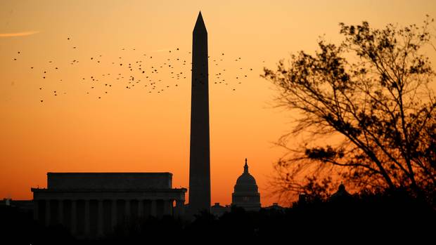 Birds fly over the Lincoln Memorial, the Washington Monument and the U.S. Capitol at sunrise on Election Day in Washington.