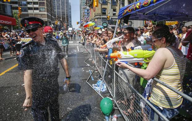 A police officer gets sprayed by water guns during the World Pride gay pride Parade in Toronto, June 29, 2014. 