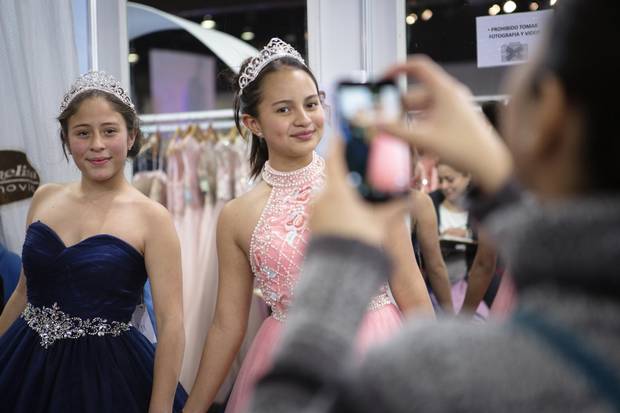 (L-R) Vanessa Jardon and Julieta Leon, fourteen year old best friends from Mexico City have their photo taken while trying on dresses at the Picchelina stand at 15 Fest, a quinceañera convention in Mexico City, Mexico. Alicia Vera/The Globe and Mail