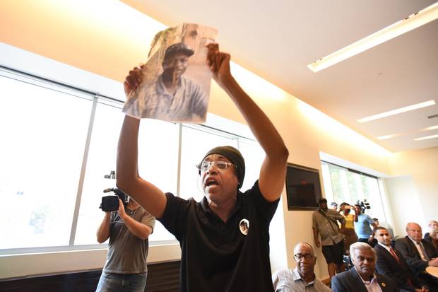 Holding a photo of Andrew Loku, Cecil Peter speaks out against carding during a public consultation on street checks in Toronto.