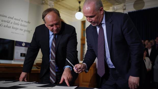 B.C. NDP leader John Horgan and B.C. Green party leader Andrew Weaver sign an agreement on creating a stable minority government during a press conference in the Hall of Honour at Legislature in Victoria, B.C., on Tuesday, May 30, 2017. 