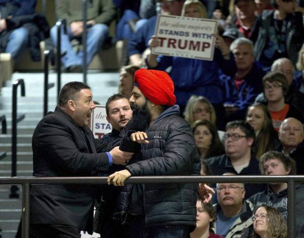 A protester, right, is removed after interrupting then-Republican presidential candidate Donald Trump as he speaks at a rally at Muscatine High School in Muscatine, Iowa, on Jan. 24, 2016.