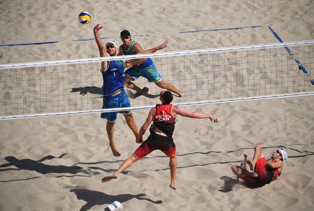 Bruno Oscar Schmidt (2) and Alison Cerutti of Brazil (1) and Josh Binstock (1) and Samuel Schachter of Canada (2) in action during the Men's Beach Volleyball preliminary round Pool A match on Day 1 of the Rio 2016 Olympic Games at the Beach Volleyball Arena on August 6, 2016 in Rio de Janeiro, Brazil.