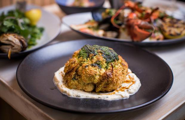 The cauliflower is served like a steak in one big, browned head drizzled with spicy green chermoula and tart pomegranate molasses.