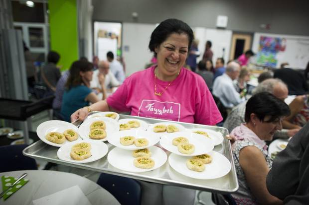 Rawaa Mahouk serves a tray of ‘lady’s bracelet’ desserts at during Tayybeh’s Shades of Green Festival in vancouver on May 26.