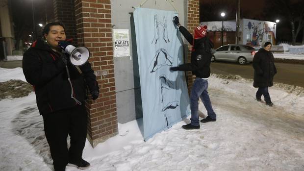 Ninoondawah Richard speaks as Michael Redhead Champagne hangs a 