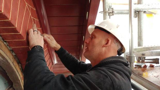 Barkley Hunt of Hunt Heritage works on a tuckpointed brick exterior.