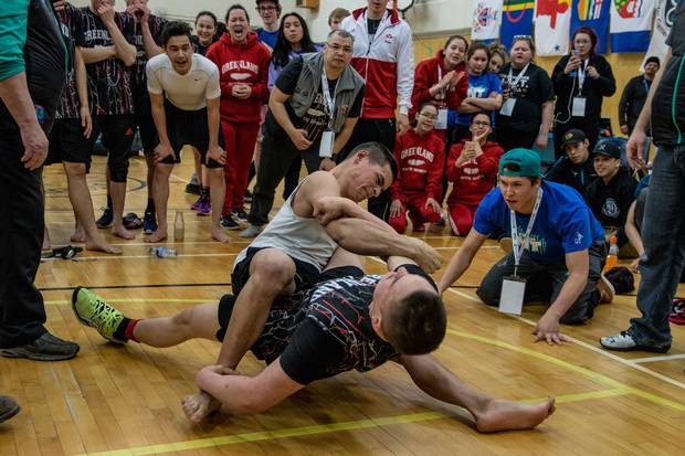 Greenland's Mick Josefsen, foreground, pulls over the Northwest Territories' Kobe Keevik in the final round of the competition to win the first gold medal for his home country at the Arctic Winter Games. In the arm pull, competitors face another with their legs intertwined and one arm wrapped around the other at the elbow. The loser is the one who releases their grip first.