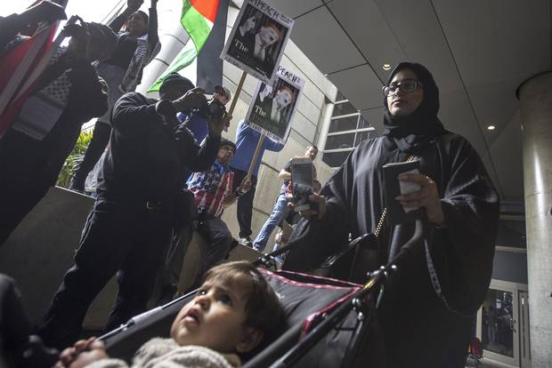 A woman and child, at Los Angeles International Airport on Saturday, pass near demonstrators who support a court ruling that grants a nationwide temporary restraining order against Donald Trump’s presidential order to ban immigration to the United States from seven Muslim-majority countries.