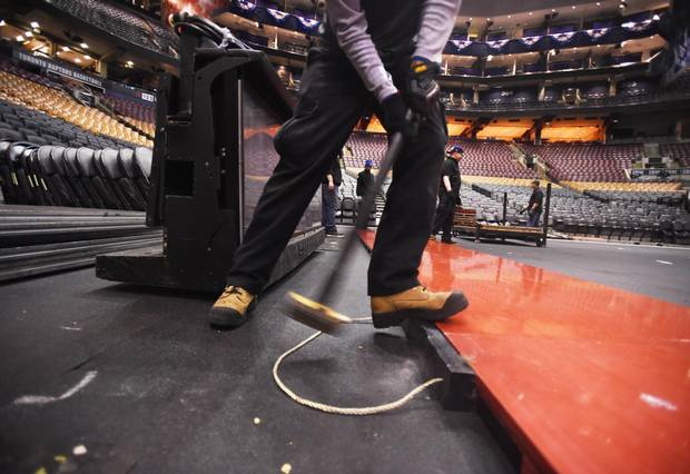 Anthony Ellis swings a sledge hammer while lining up the first course of sections of the basketball court at the Air Canada Centre. Following the Toronto Maple Leaf's final playoff game, workers are pictured installing the basketball court as they convert the Air Canada Centre from a hockey rink to a basketball court on April 24 2017 in preparation for the Toronto Raptors basketball team's game tonight.