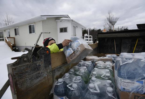 Marvin McLeod reaches for bottles of water while making deliveries to homes on the Serpent River First Nation on Dec. 21, 2016.