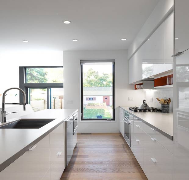 In the narrow kitchen, dollars have been saved and visual clutter removed by hacking an IKEA kitchen to support an in-line blower over the stove.