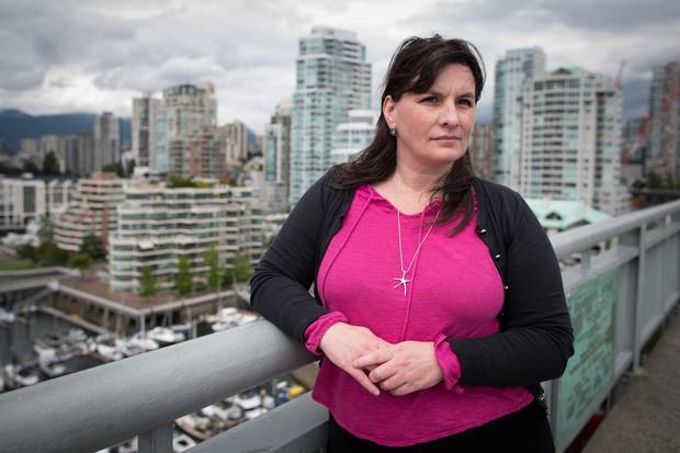 Karen Sawatzky, who has written her masters thesis on the impact of Airbnb on the rental market, stands for a photograph on Vancouver's Granville Street Bridge as condos fill the skyline behind her.