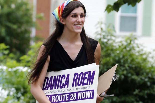 Danica Roem brings campaign signs as she greets voters while canvasing a neighbourhood in Manassas, Va., on June 21, 2017.