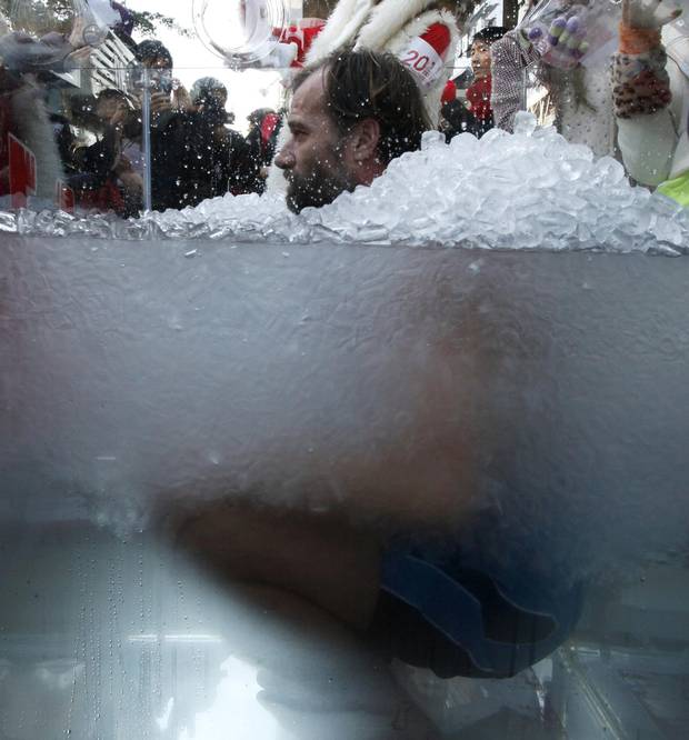Wim Hof immerses in ice water during a performance to arouse the public awareness of global warming in Hong Kong.