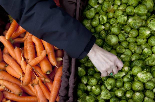 Customers shop for vegetables in the Fiore Farms booth at the Vancouver Winter Farmer's Market at Nat Bailey Stadium on Jan. 27, 2013.